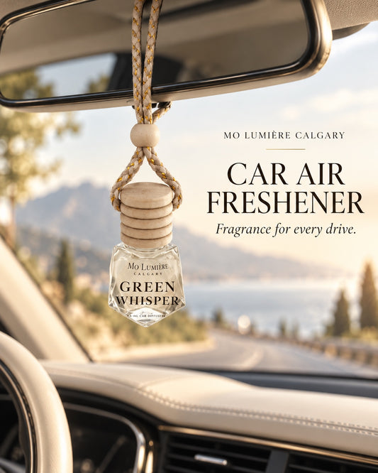 Green Whisper car air freshener hanging inside a car